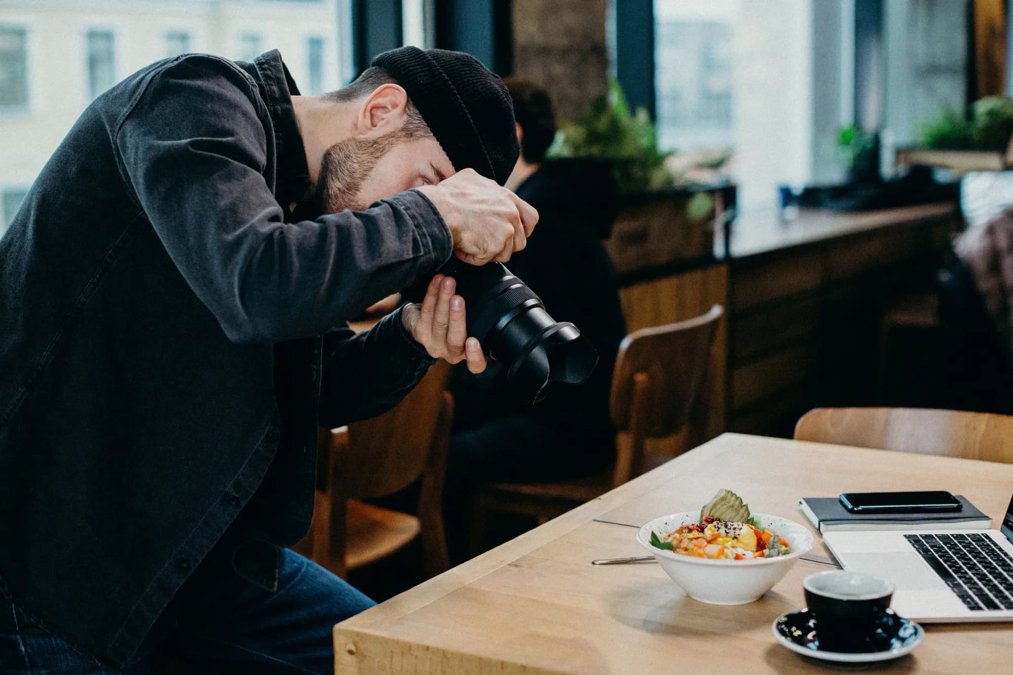 Photographe culinaire en train de photographier un plat au restaurant